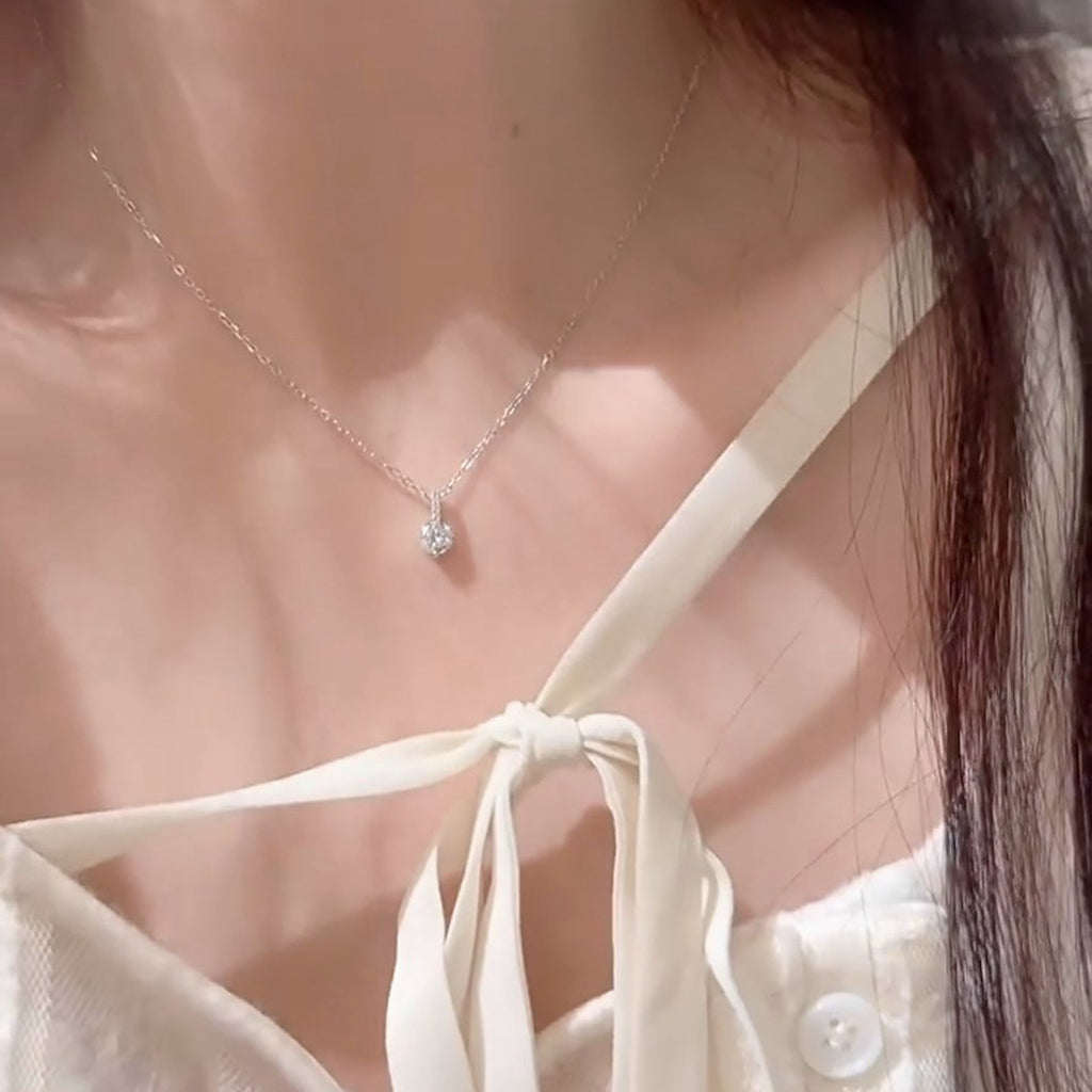 Luna Solitaire Moissanite Necklace worn at the collarbone, round moissanite pendant with a small stone bar