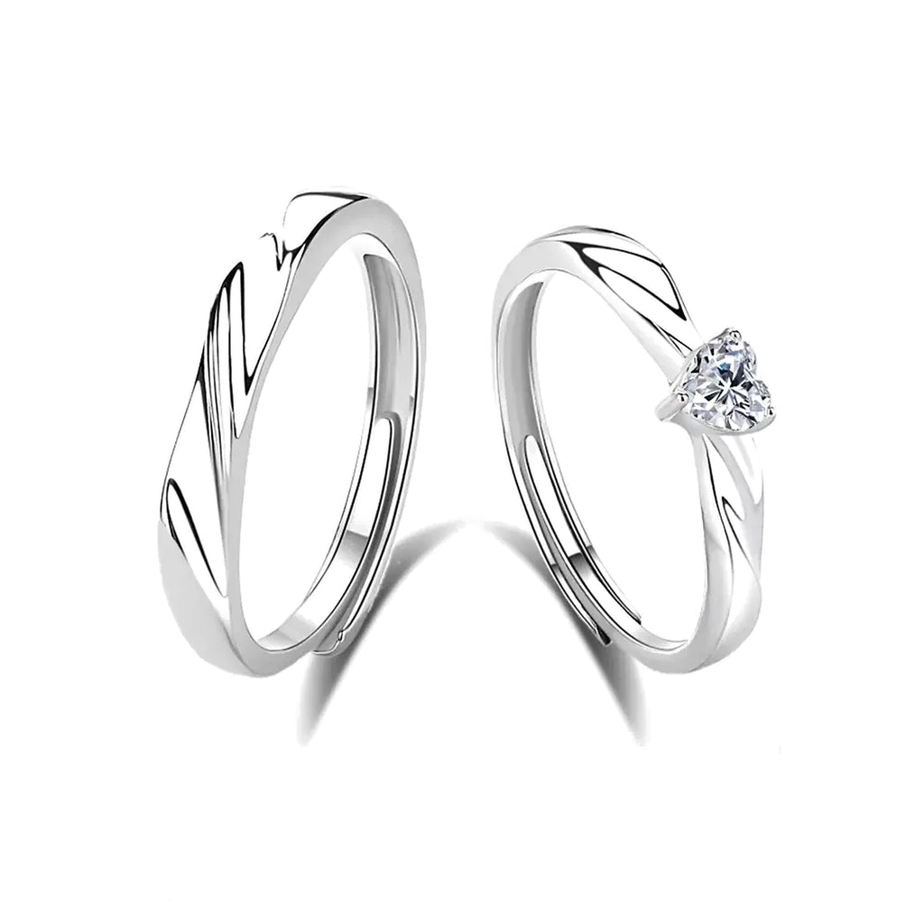 Eternal Flow Couple Ring, matching pair of adjustable open rings, one with a heart-shaped stone, on a white background